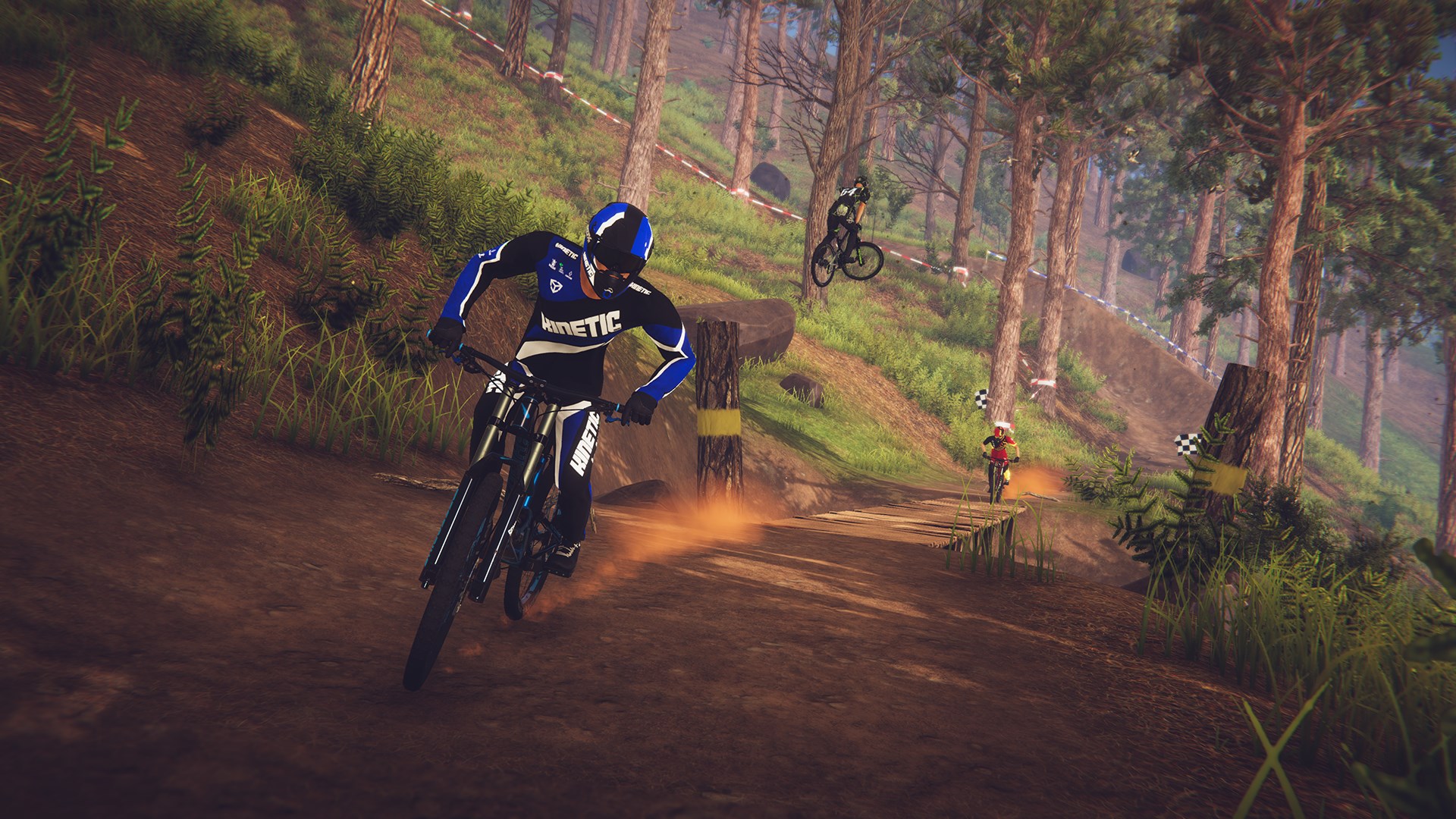 A screenshot from Descenders shows a mountain biker racing downhill on a forested trail.
