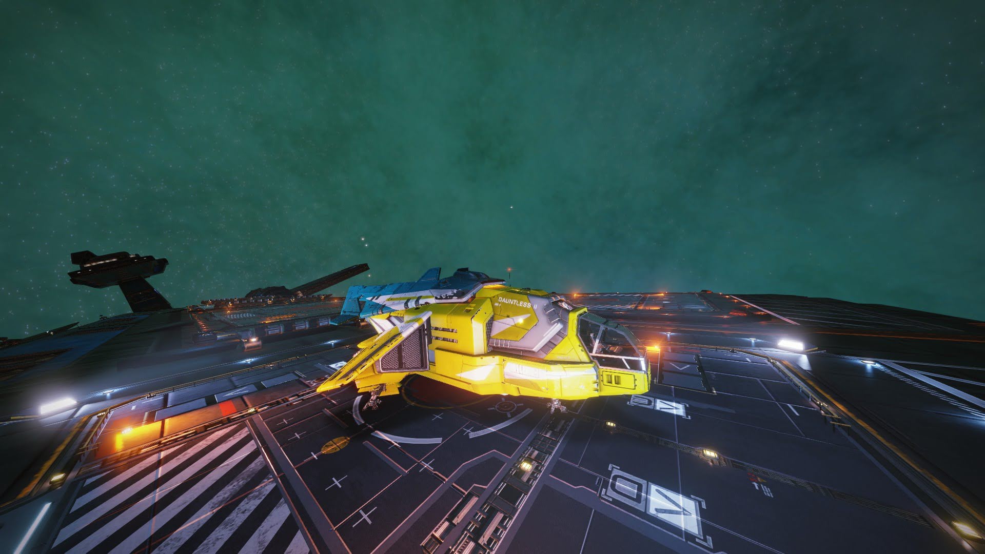 A blue and yellow marked spaceship parked on a massive fleet carrier. Stars adorn green tinted space. Screenshot by author.
