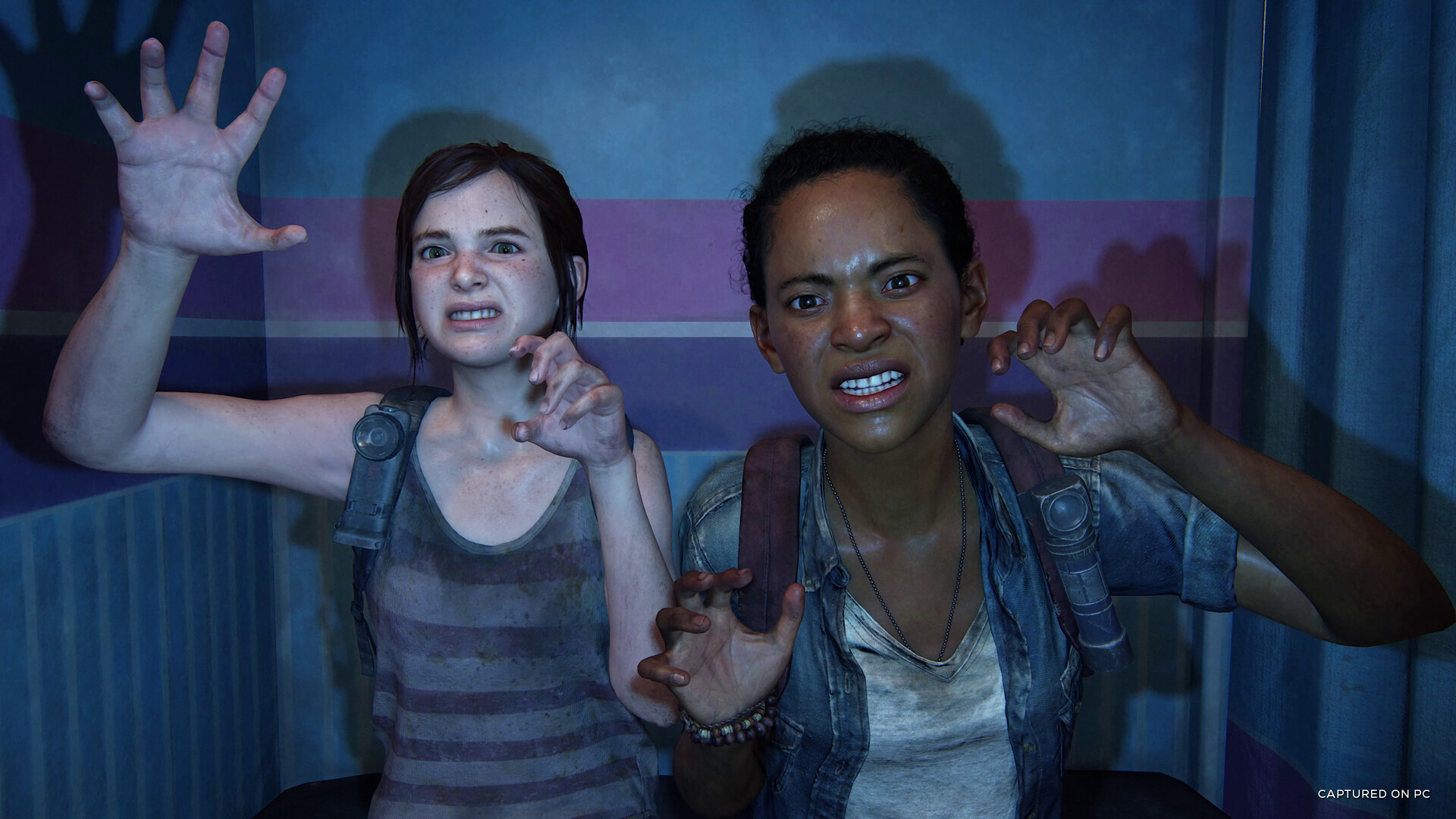 The Last of Us shows Ellie and Riley making monster faces and clawing at the camera in a photo booth. Image courtesy of PlayStation Studios.