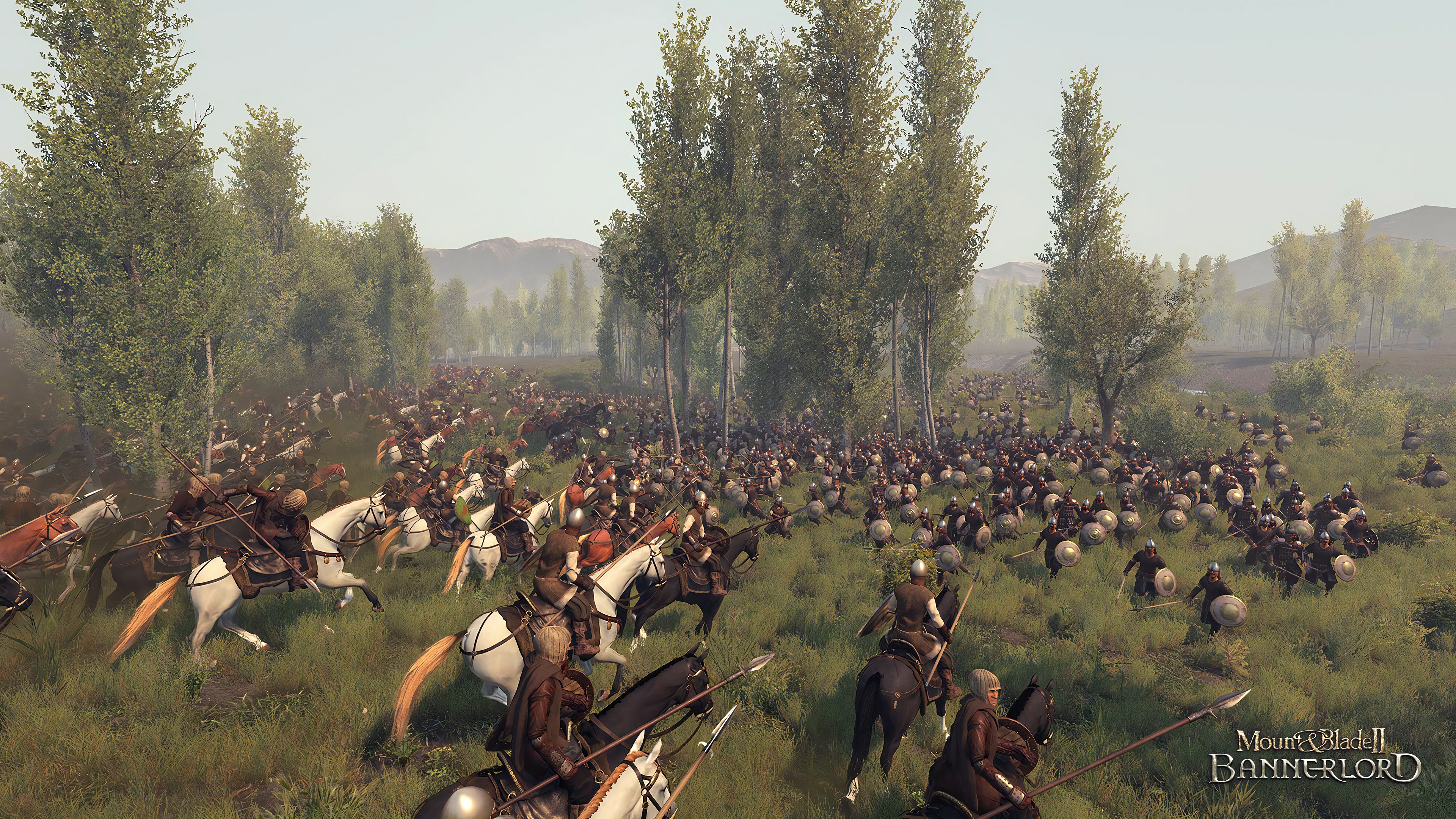 A screenshot from Mount & Blade II: Bannerlord depicts a large medieval battle with many soldiers on horseback in a forested area.