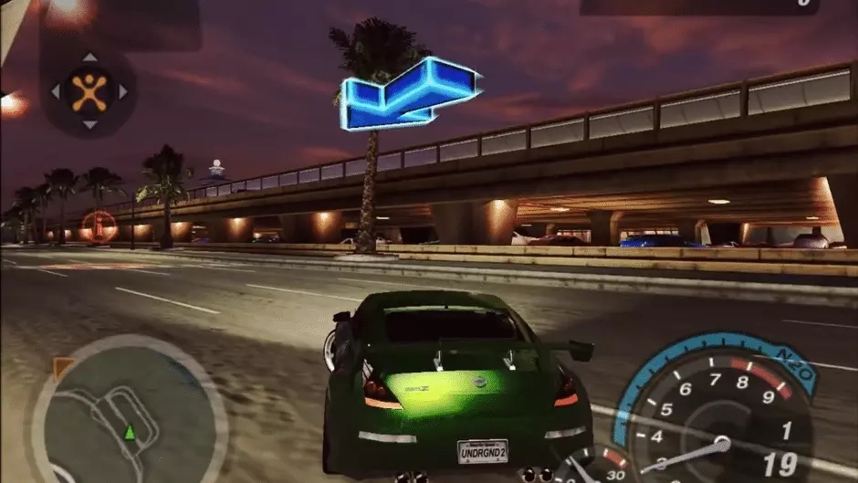 A green sports car driving through the night city in Need fro Speed: Underground 2.