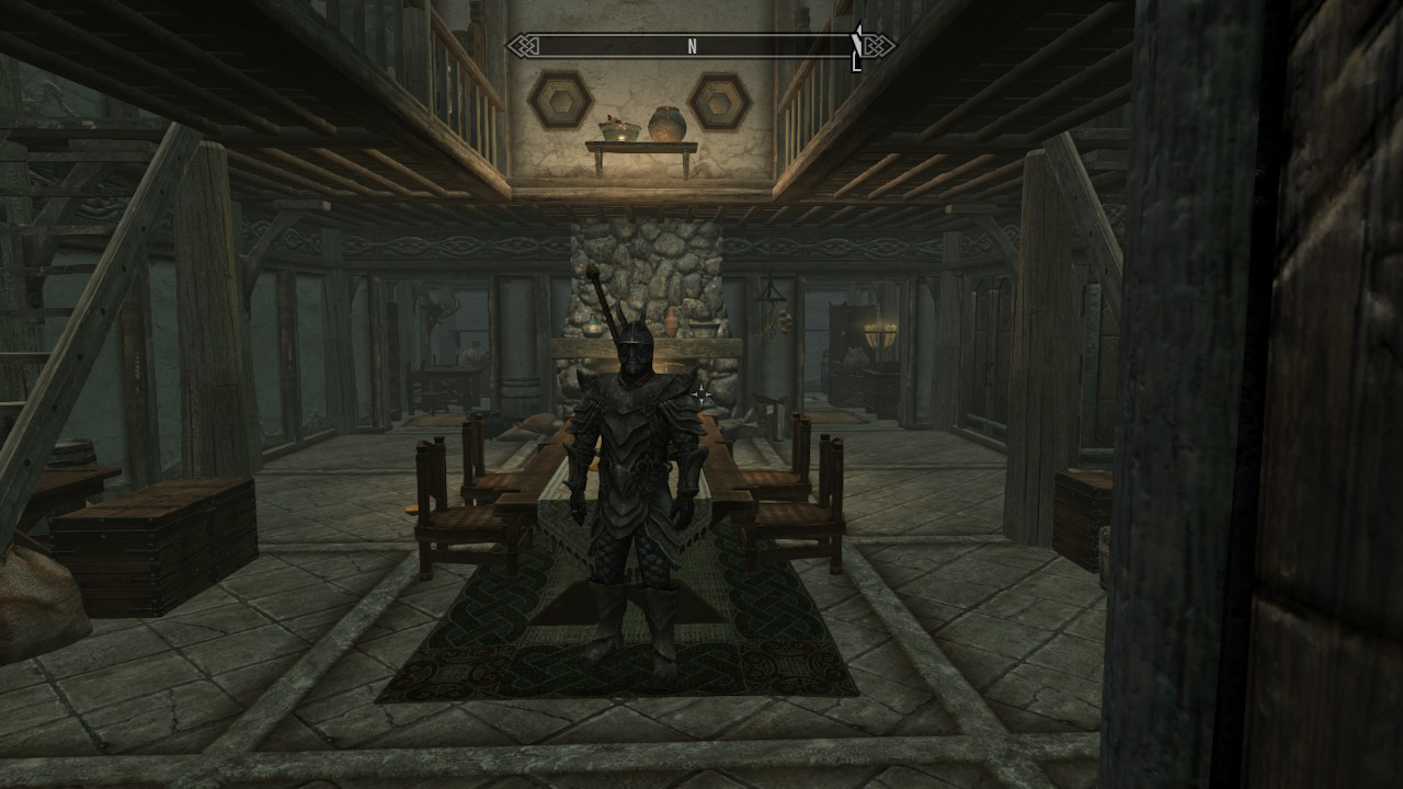 Skyrim protagonist adorned in heavy armor standing in a large empty house. Screenshot by author.