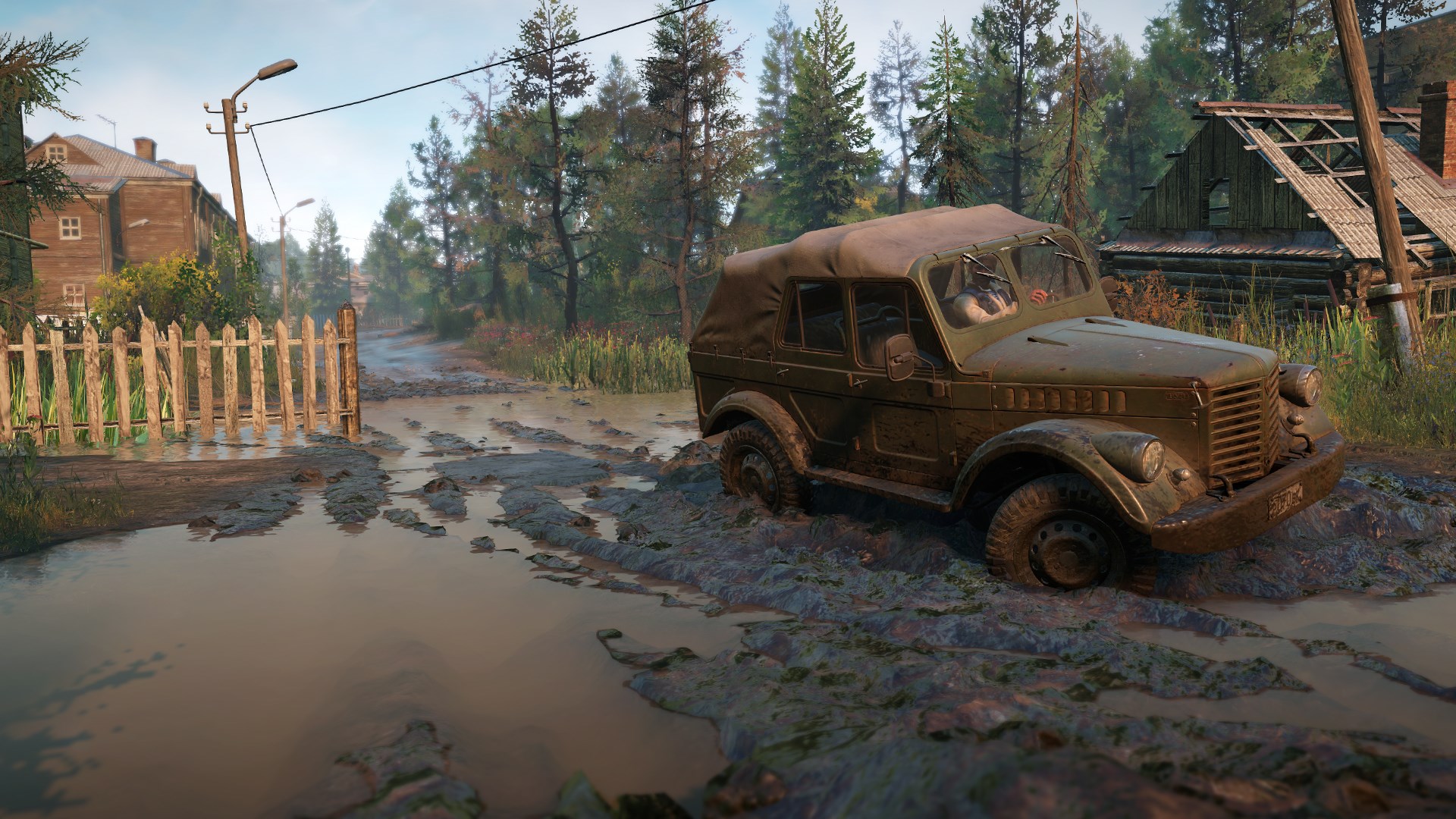 A screenshot from Snowrunner shows a rugged off-road vehicle stuck in deep mud in a forested, rural area.