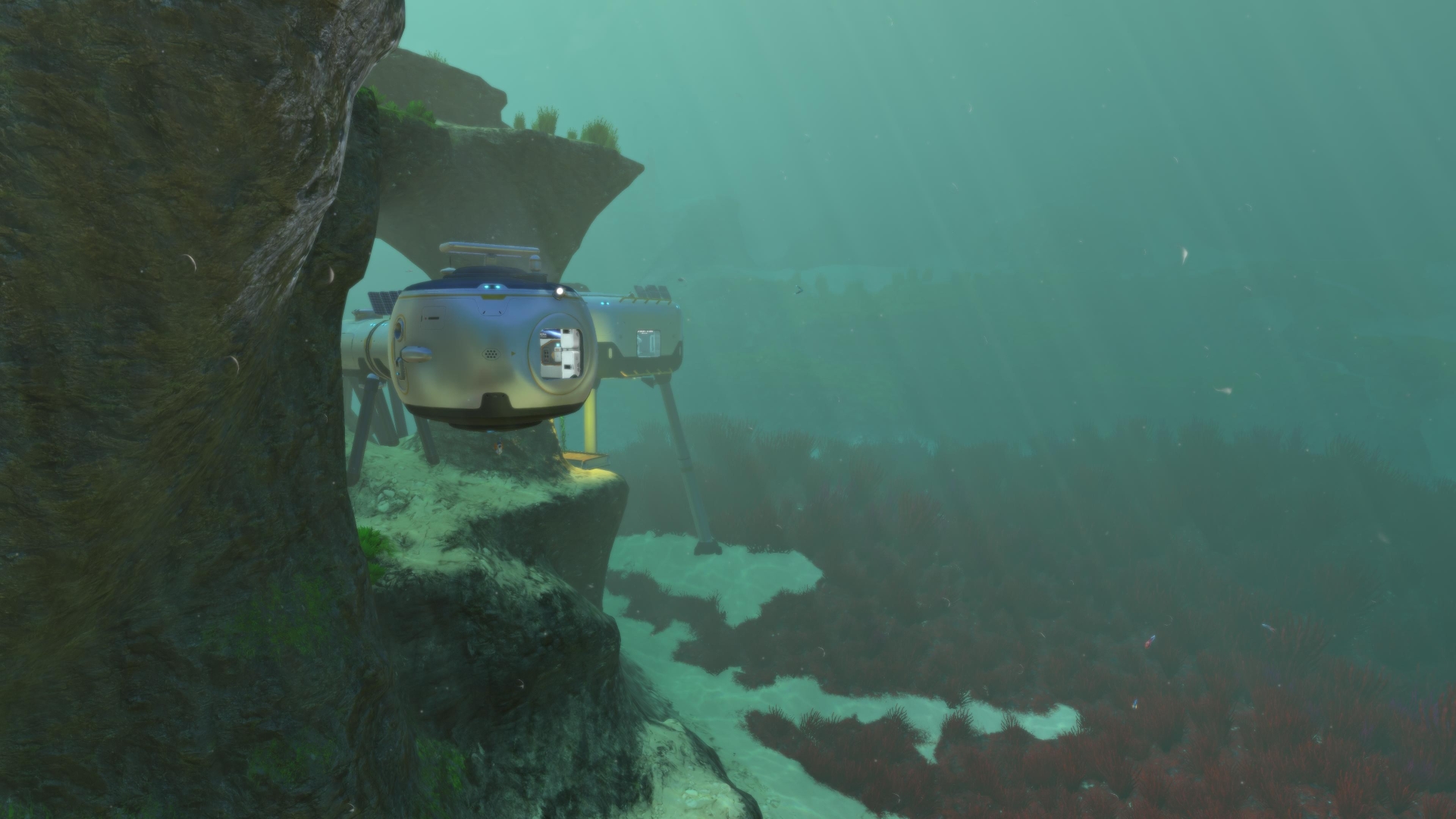 A submerged base module in Subnautica, nestled against a rocky cliff.