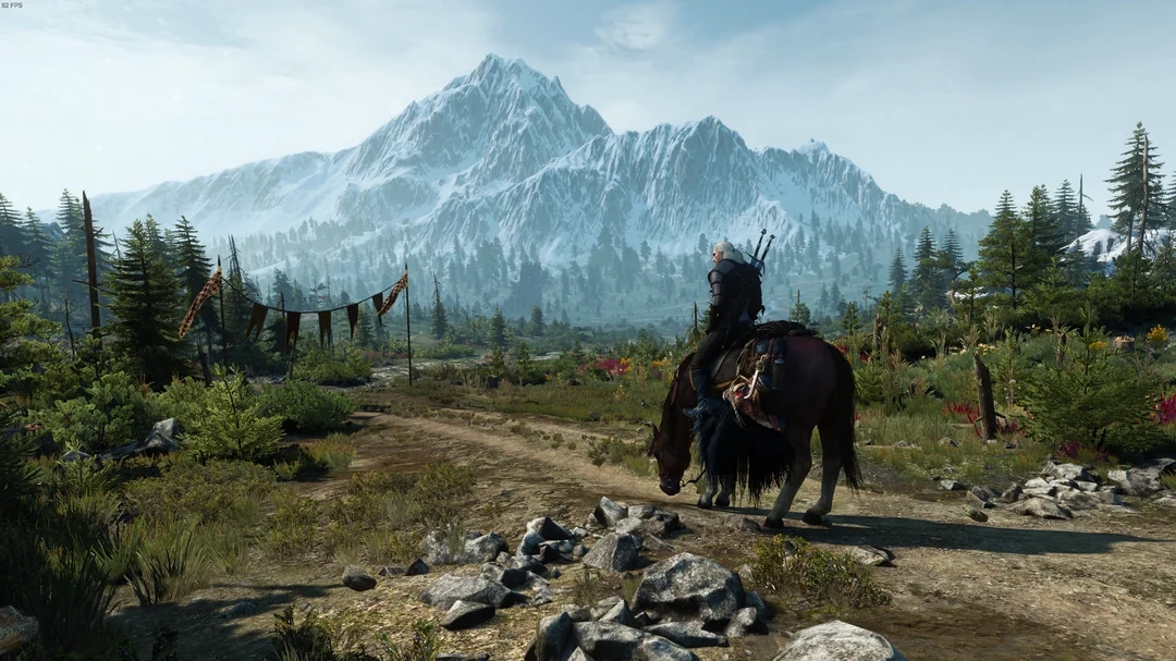 Geralt, protagonist of The Witcher 3: Wild Hunt, riding his horse towards the mountains in a distance.